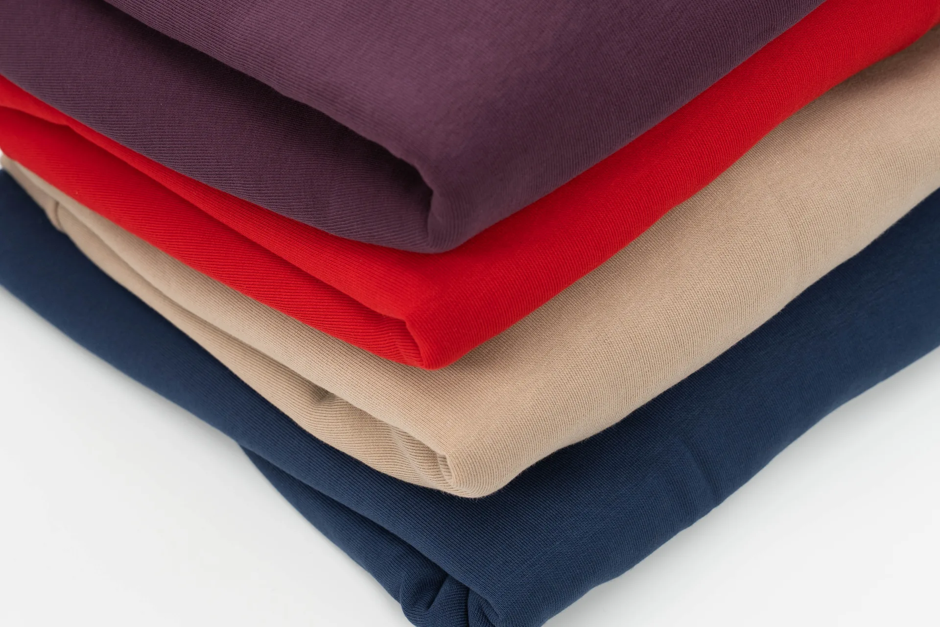 Sudaderas de punto dobladas en burdeos, rojo, camel y marino: producción de colección para una marca en el taller de Maridem, A Coruña
